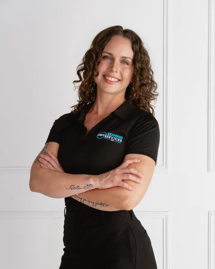 Haley, owner of NWA Cleaning Services, smiling in a company polo